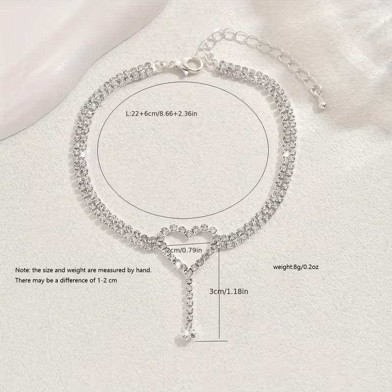 Elegante tobilleras con corazón y pequeñas piedras de cristal.