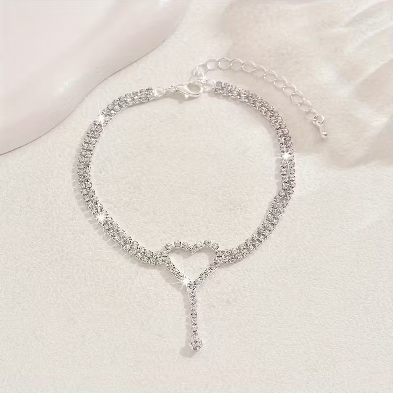 Elegante tobilleras con corazón y pequeñas piedras de cristal.